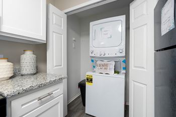 The kitchen features granite counters, wood-look flooring and the laundry closet.